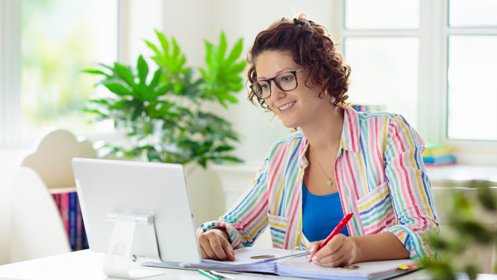 Happy teacher doing work on computer