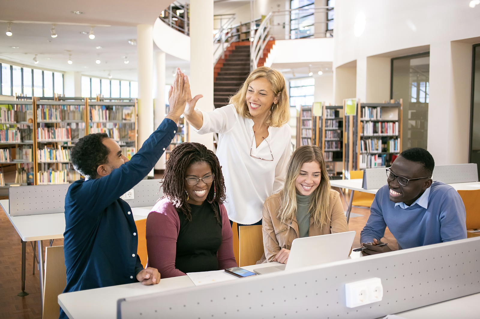 Adults working together in a library and celebrating